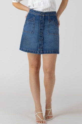 Person wearing a blue denim skirt on a white background