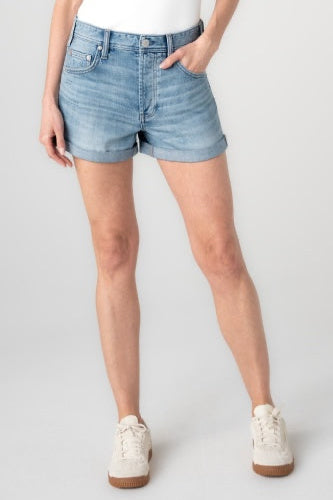Person wearing light blue denim shorts on a plain background