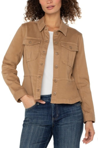 Woman wearing a tan jacket over a white shirt and blue jeans on a white background