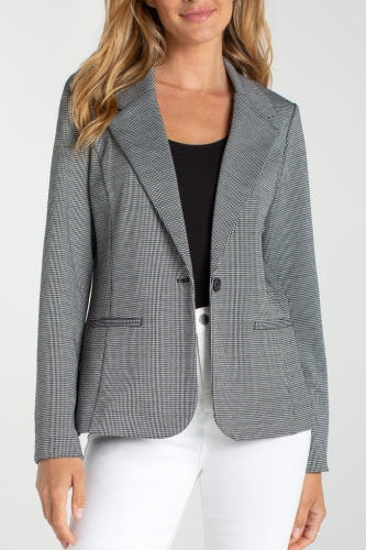 Woman wearing a gray checkered blazer over a black top and white pants on a white background