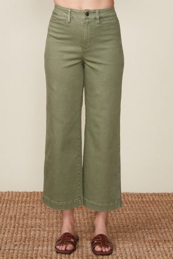 Green wide-leg pants worn by a person on a beige background