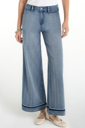 Person wearing blue wide-leg jeans on a white background