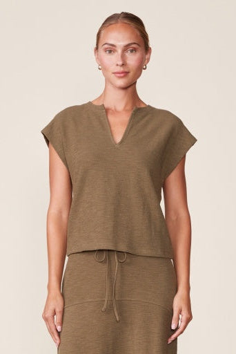 Woman wearing a brown outfit against a beige background