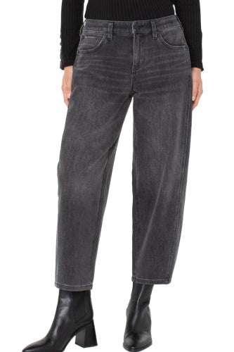 Person wearing gray jeans and black boots on a white background