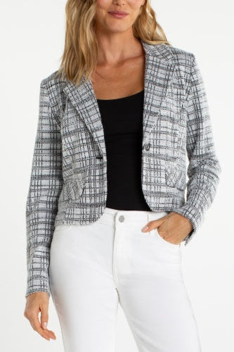 Woman wearing a plaid blazer over a black top and white pants on a white background
