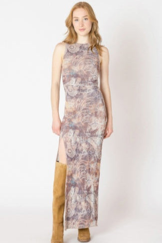 Woman wearing a sleeveless patterned dress with a slit on a white background