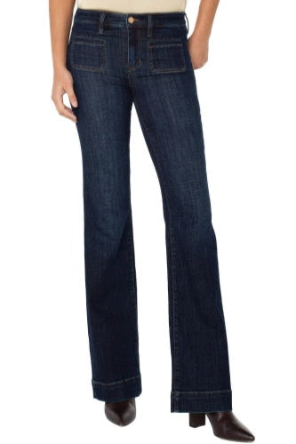 Dark blue jeans worn by a person on a white background
