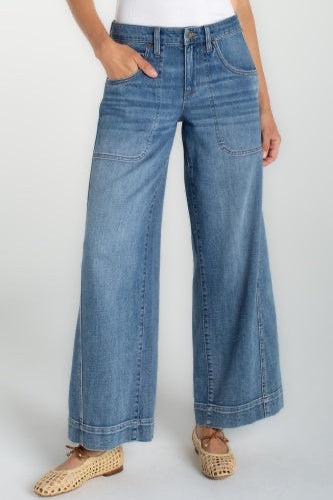 Person wearing blue wide-leg jeans on a white background