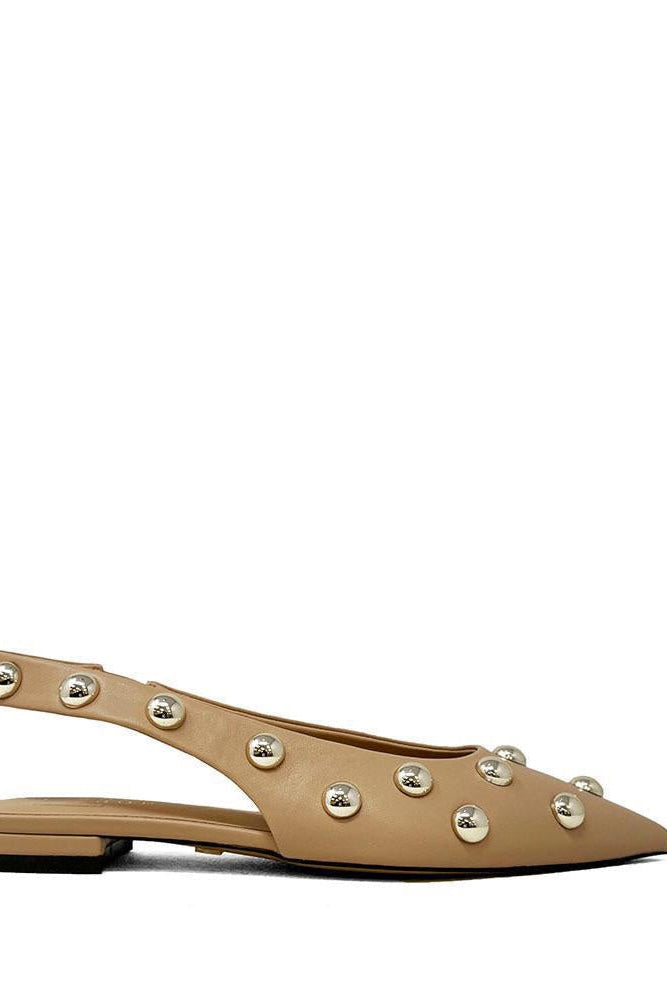 Beige flat shoe with decorative studs on a white background
